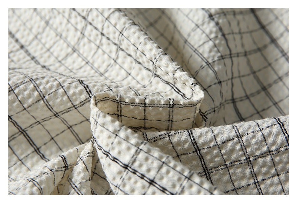 Close-up of the shirt collar and layered checked fabric.