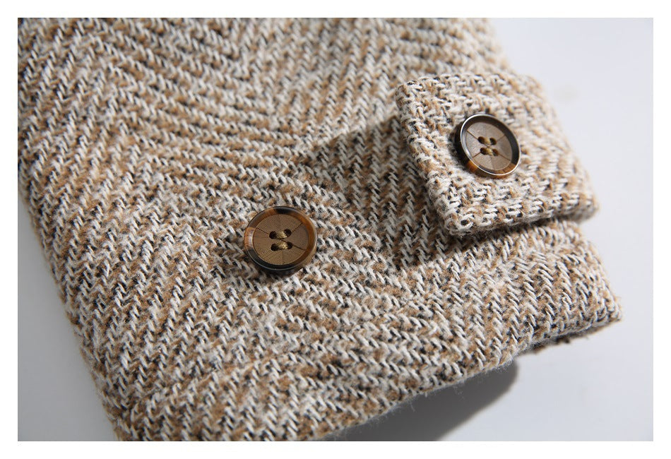 Close-up of a brown and cream textured knit garment with two brown buttons and a folded cuff.