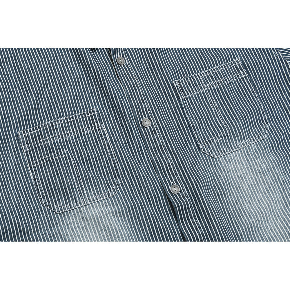 Close-up of a dark blue shirt with narrow white pinstripes, two chest pockets and gray buttons.