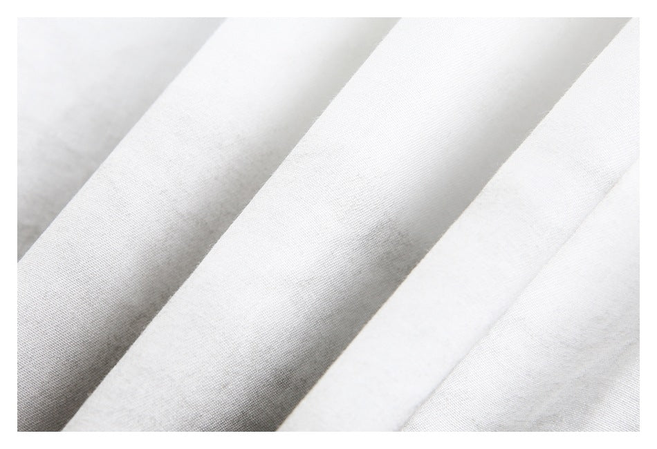 Close-up showing the fine weave and folds of white garment fabric.