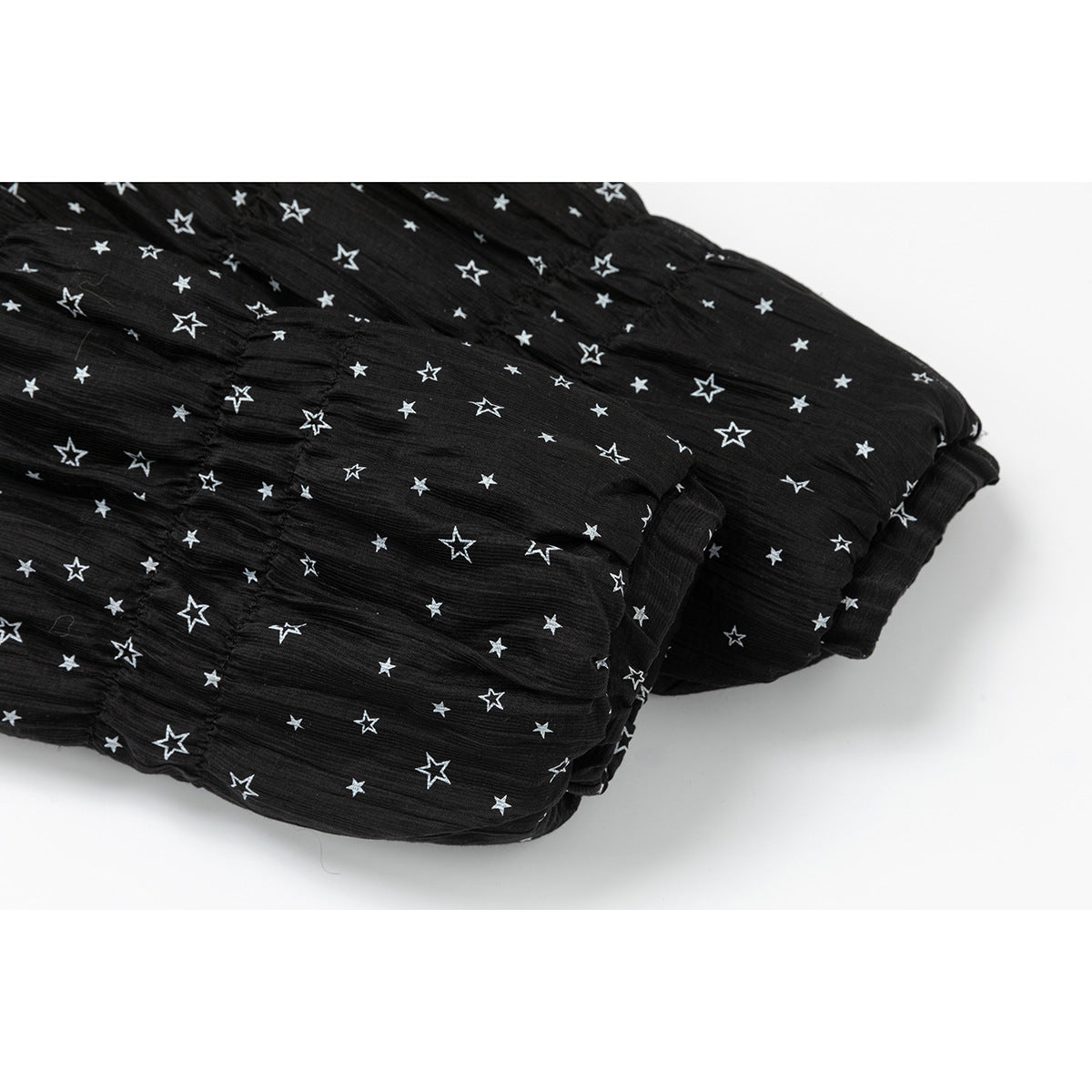 Close-up of the black star-print jacket's gathered sleeve cuff.