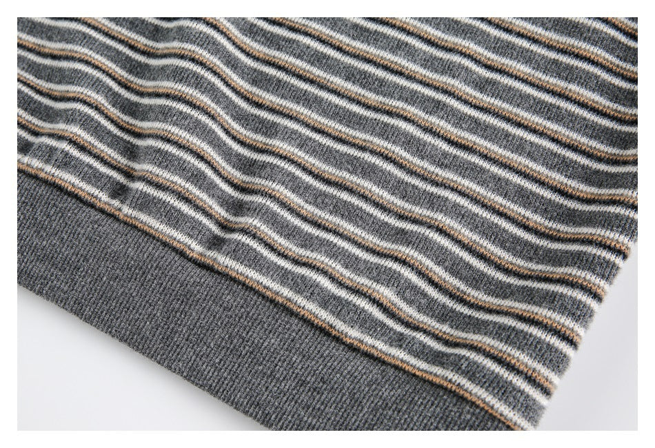 Close-up of the gray striped knit garment's ribbed hem with cream and tan accent stripes.