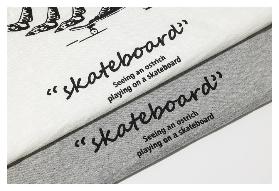 Close-up of white and heather gray T-shirts with black ostrich skateboarding graphic and English text.