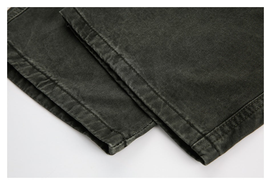 Close-up of overlapping dark charcoal garment panels with stitched hems.