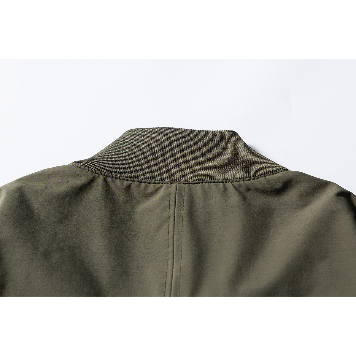 Close-up of the olive bomber jacket's back collar and center seam.