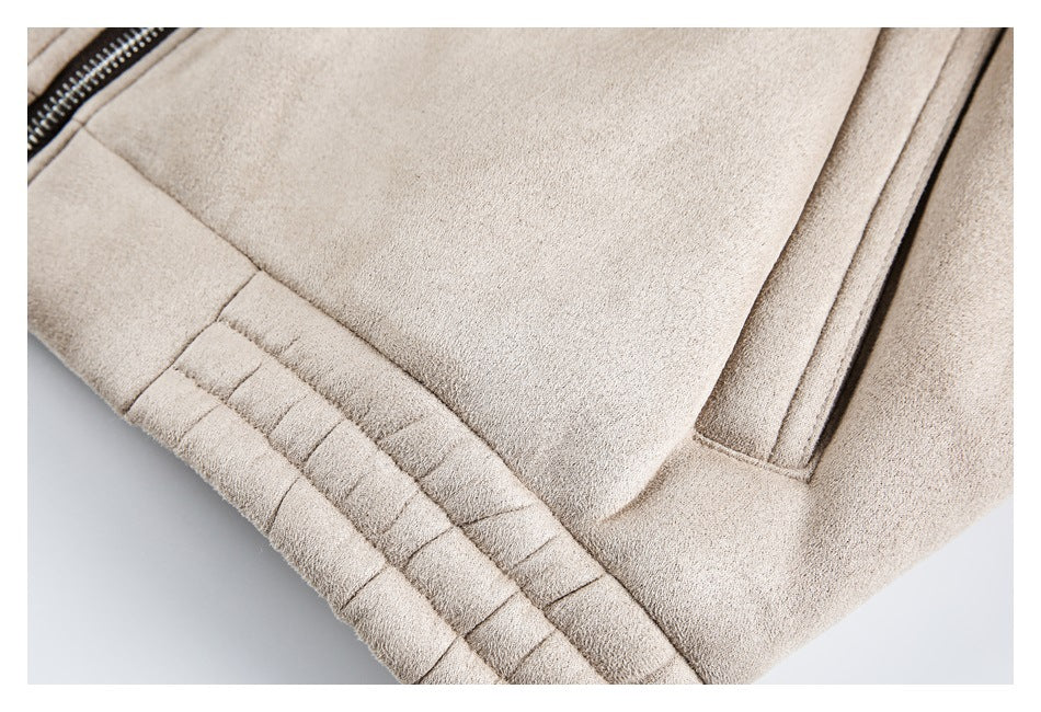 Close-up of a beige jacket showing a welt pocket, zipper edge, and stitched lower band.