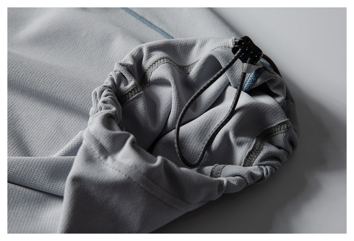 Close-up of a light gray mesh garment with a gathered edge and black drawcord toggle.