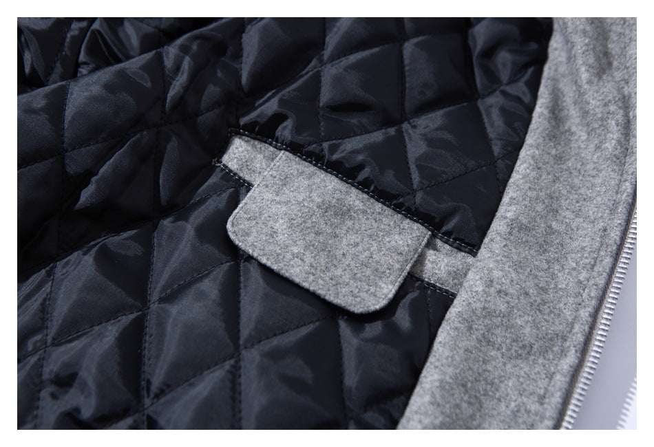 Close-up of a gray jacket's black diamond-quilted lining, gray inner tab, and front zipper edge.