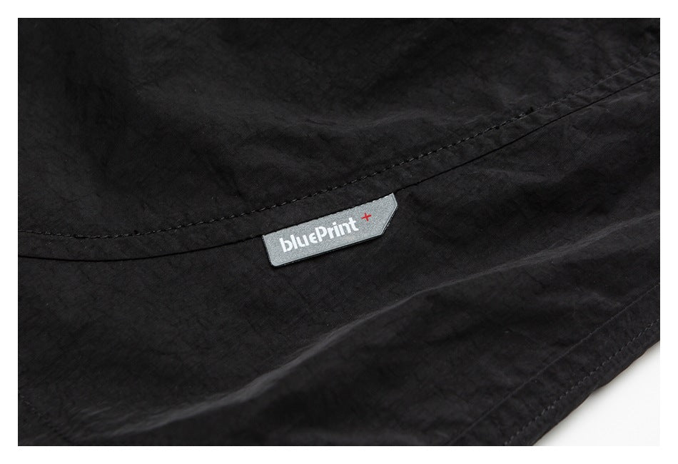 Close-up of black garment fabric and a small sewn bluePrint+ label.
