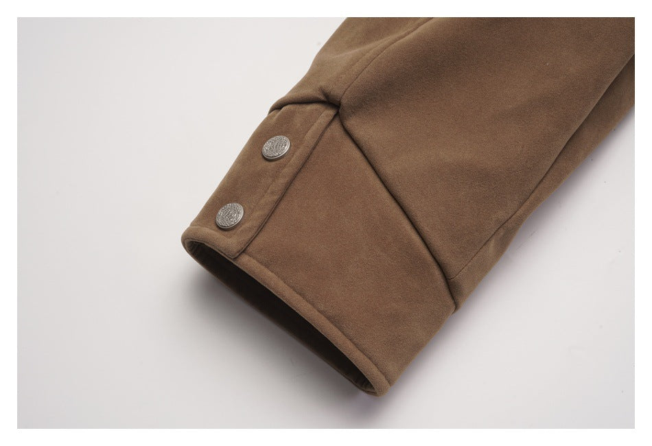 Close-up of a brown jacket cuff with two decorative silver buttons.