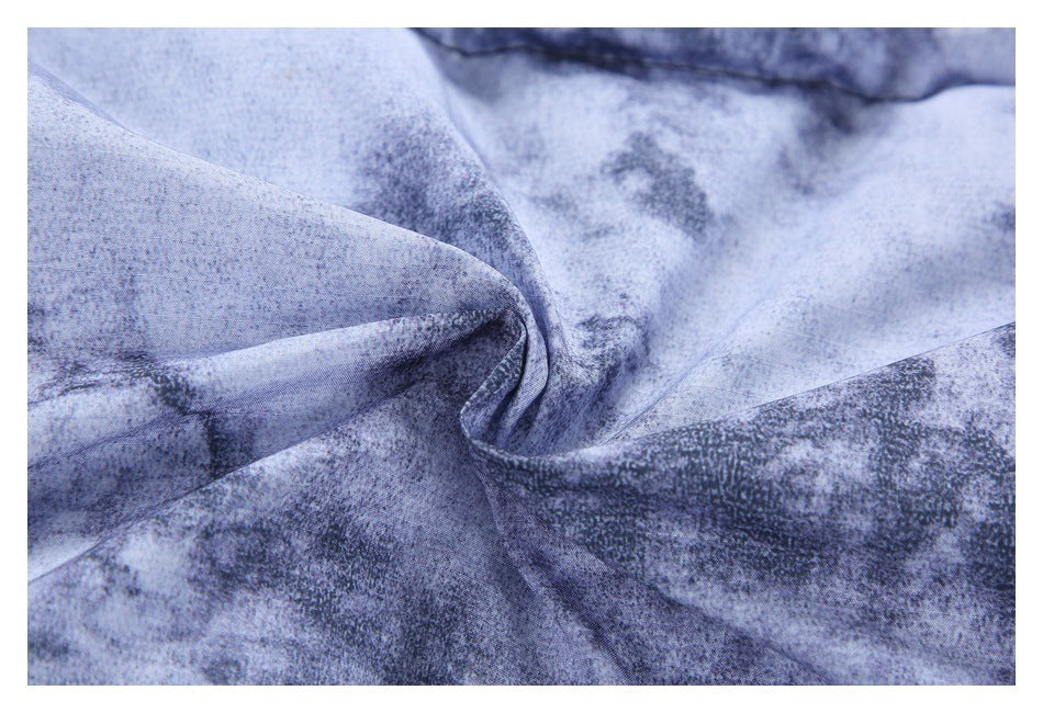 Close-up of folded blue-gray mottled fabric showing its texture and stitched edge.