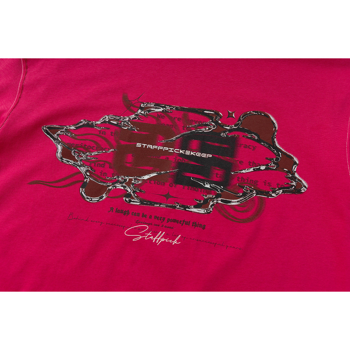 Close-up of the magenta T-shirt’s ornate black-and-silver front graphic with English lettering.