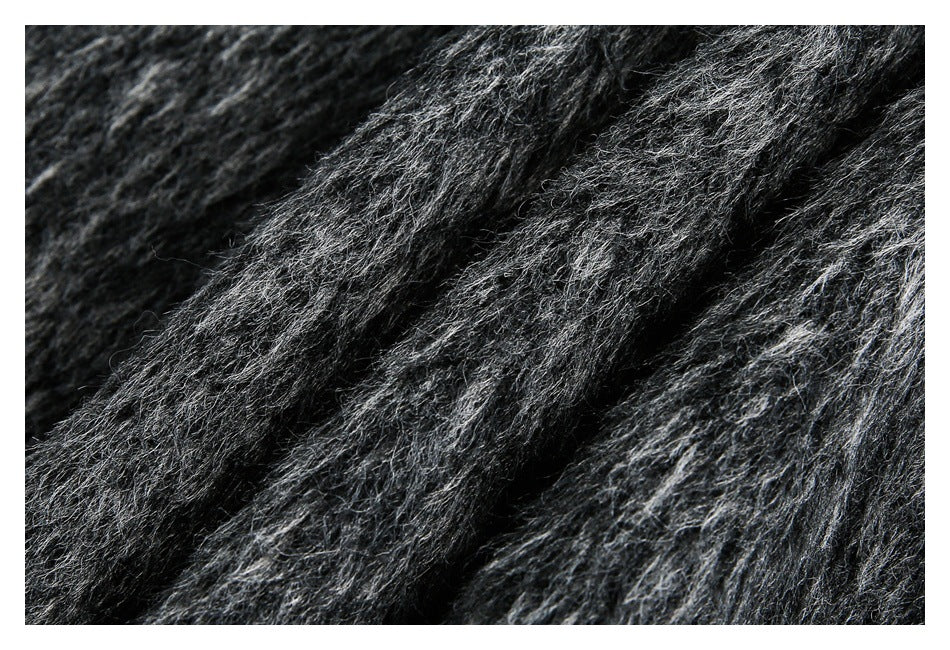 Close-up of dark charcoal gray fabric with a thick, fuzzy pile and lighter fibers.
