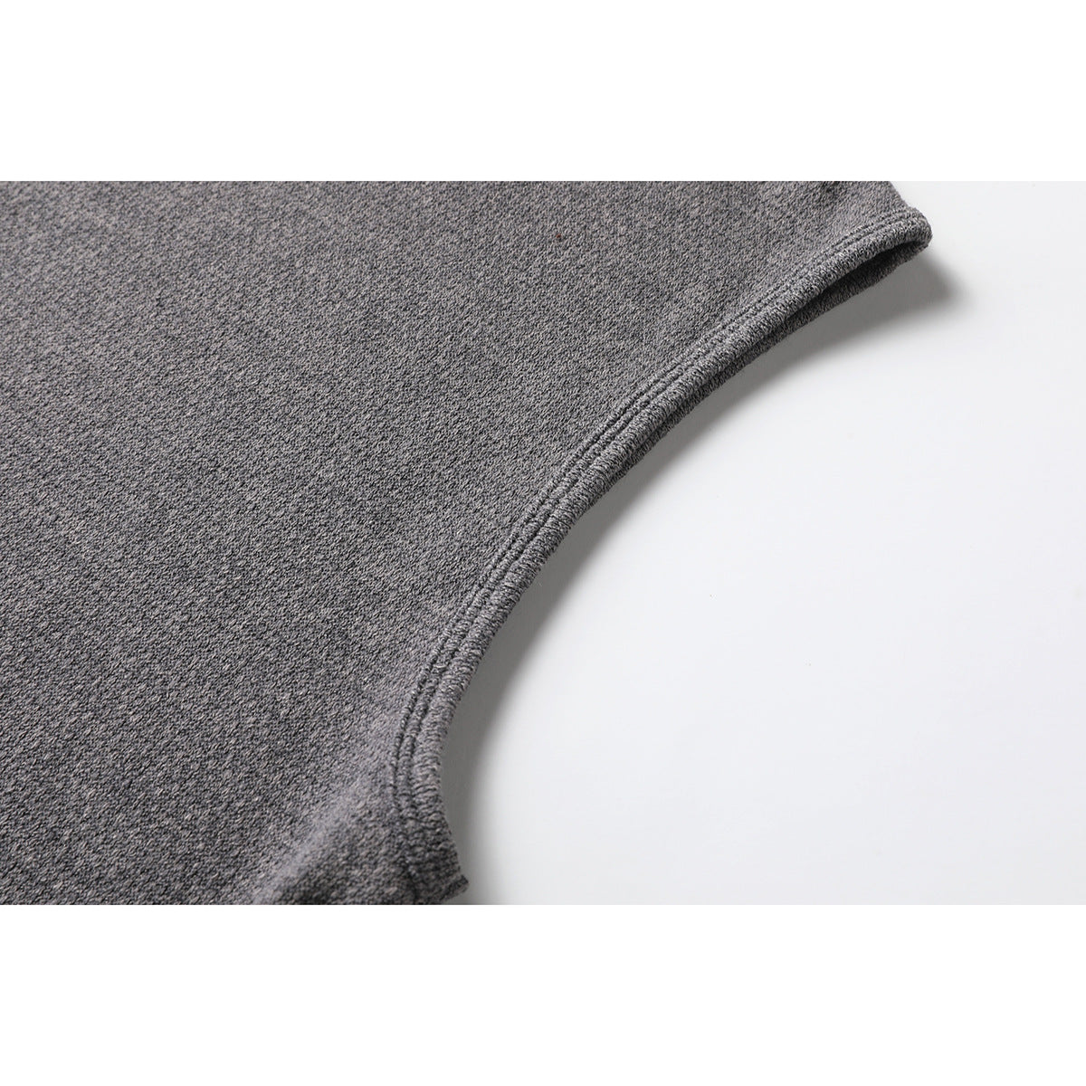 Close-up of the charcoal gray top's stitched edge and textured knit surface.