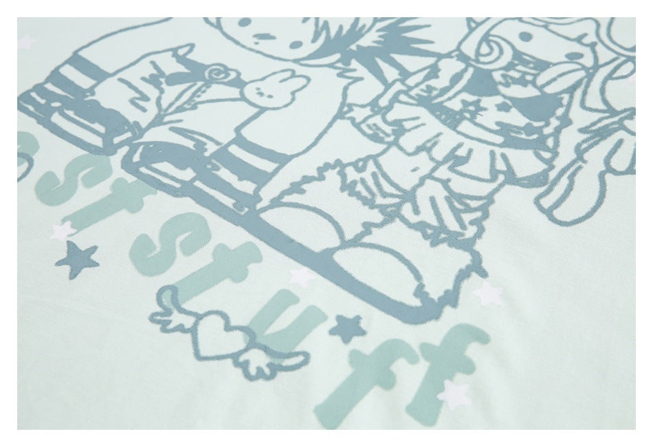 Close-up of the blue-gray cartoon character print and decorative lettering on pale mint fabric.