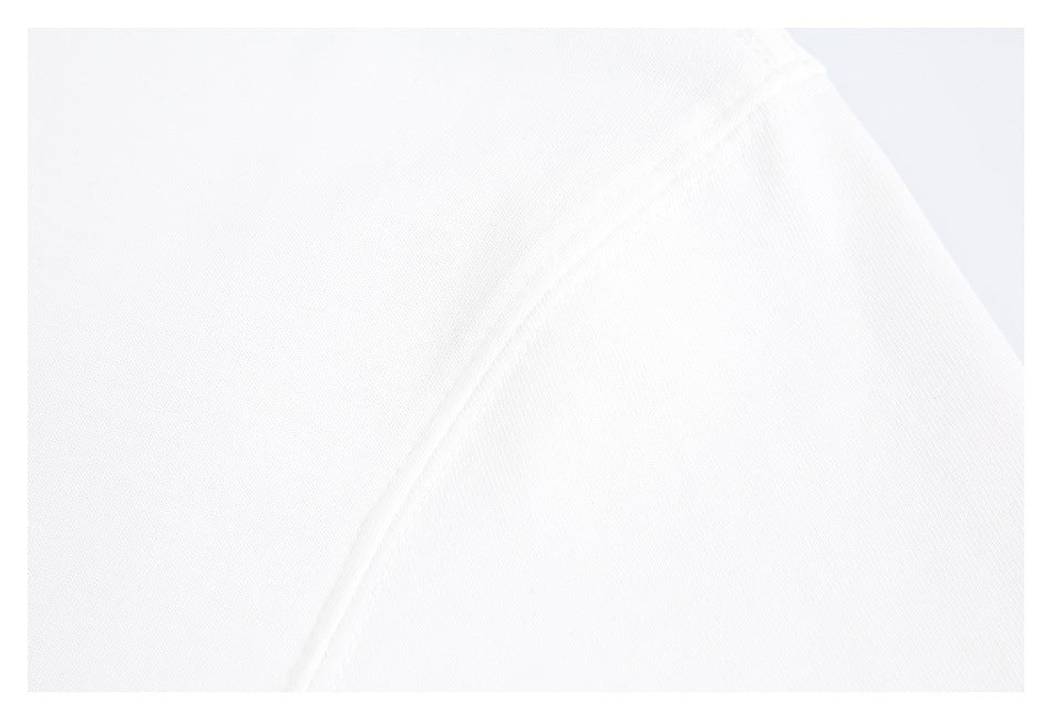 Close-up of a white T-shirt fabric panel and curved stitched seam.