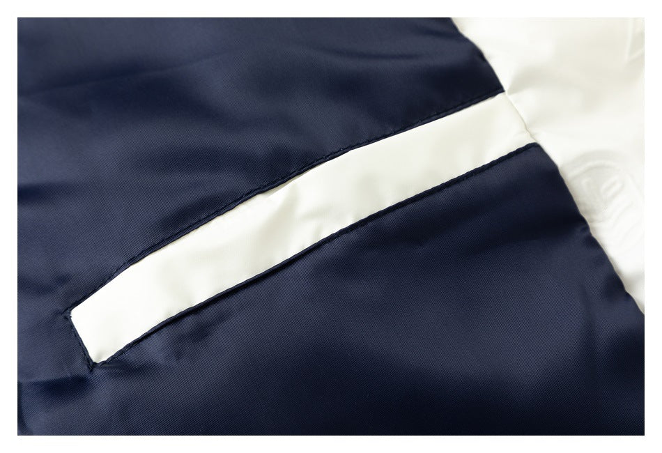 Close-up of a navy garment with a wide white diagonal panel bordered by dark stitching.