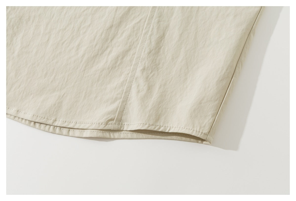 Close-up of the ivory shirt-jacket's straight stitched hem and side seam.