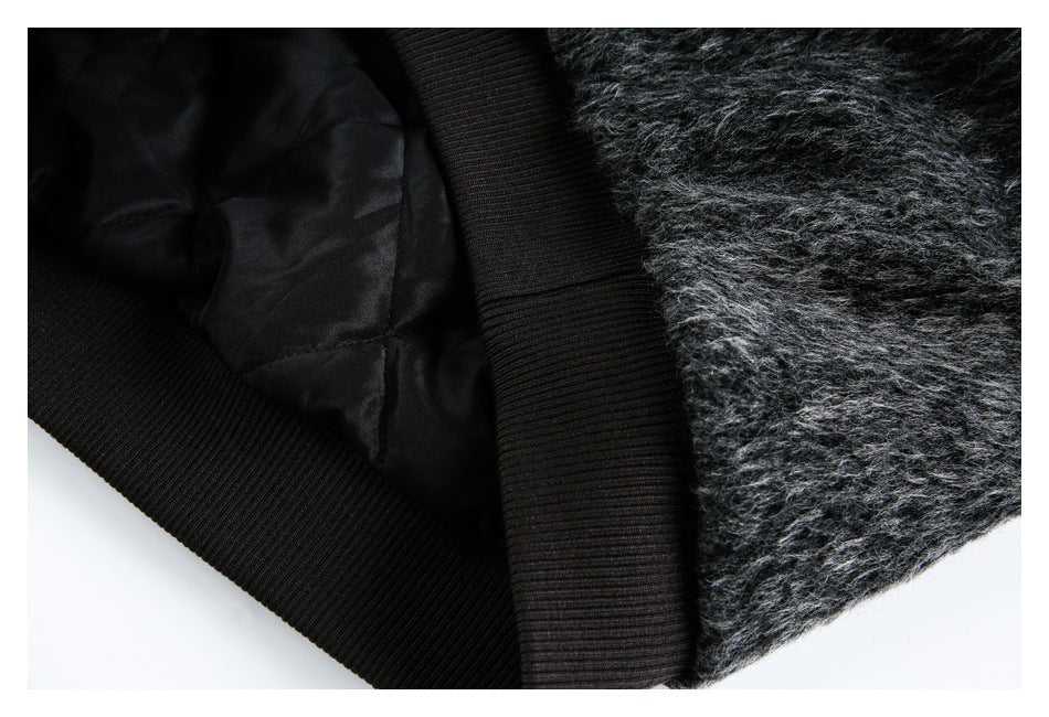 Close-up of the garment's black quilted lining and ribbed trim beside its fuzzy charcoal exterior.