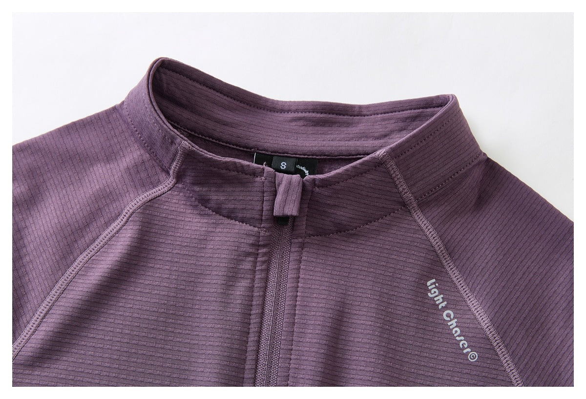 Close-up of the purple jacket's stand collar, front zipper, seams, and chest lettering.