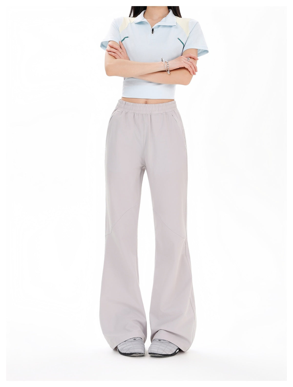 Front view of a model wearing pale gray wide-leg pants with an elastic waist and a light blue cropped polo.