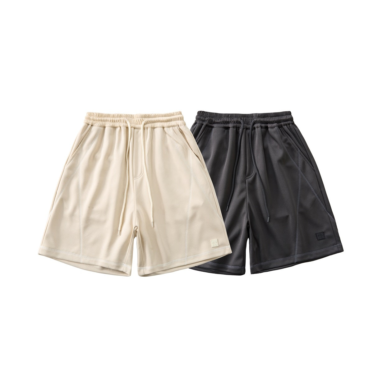 Front view of loose-fit drawstring shorts in cream and charcoal, shown side by side.