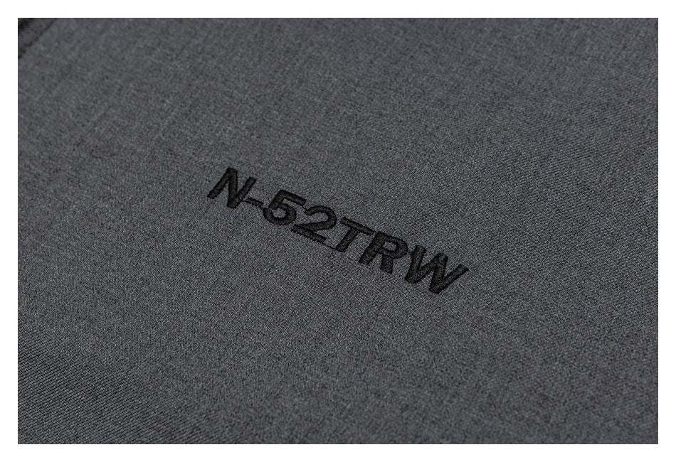 Close-up of black embroidered lettering on the charcoal-gray jacket.