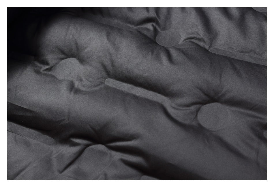 Close-up of dark padded jacket lining with stitched sections and folds.