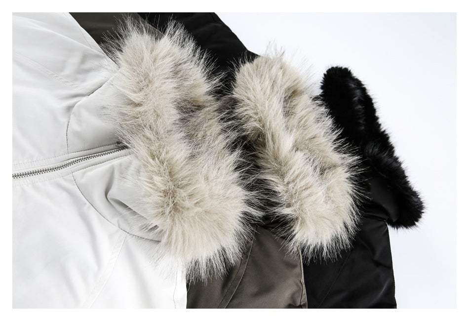 Close-up of three jackets in white, gray, and black, each with a fluffy hood trim.