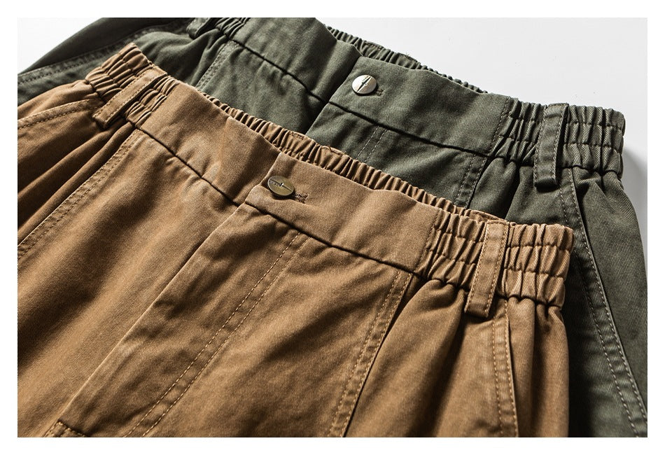 Close-up of olive and tan cargo pants showing elastic waistbands, buttons, belt loops and stitching.