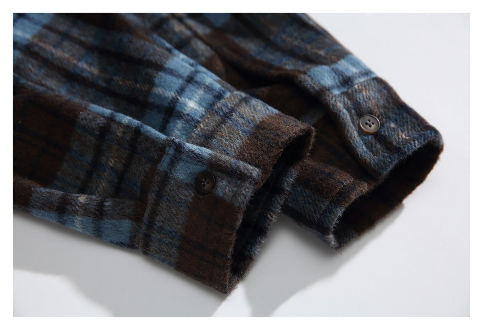 Close-up of the brown and blue plaid shirt's buttoned cuffs and sleeves.