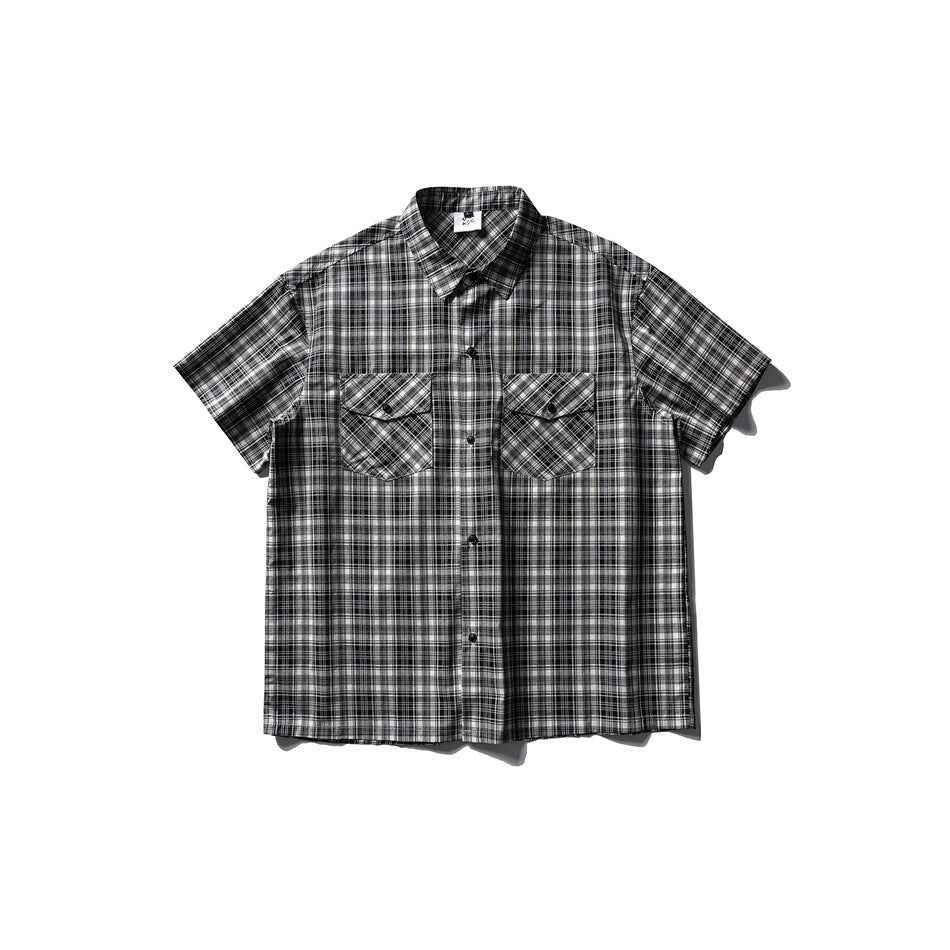 Black, white and gray plaid short-sleeve button-up shirt with two flap chest pockets, flat lay front view