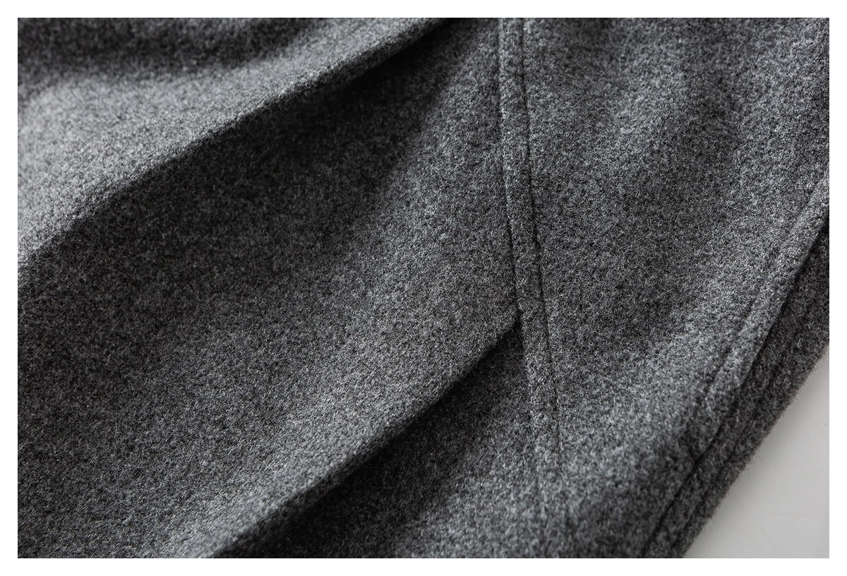 Close-up of charcoal gray trouser fabric and a vertical stitched seam.
