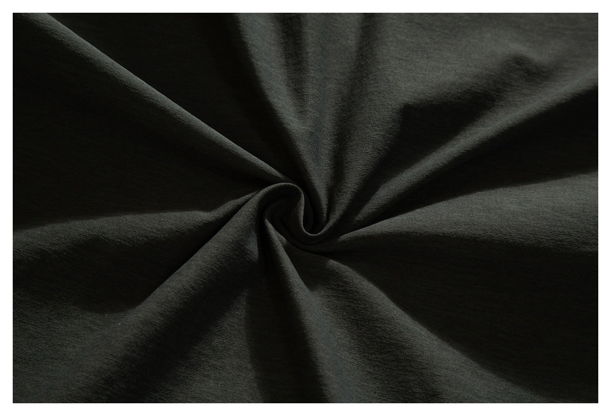 Dark charcoal fabric gathered into a spiral to show its surface and drape.