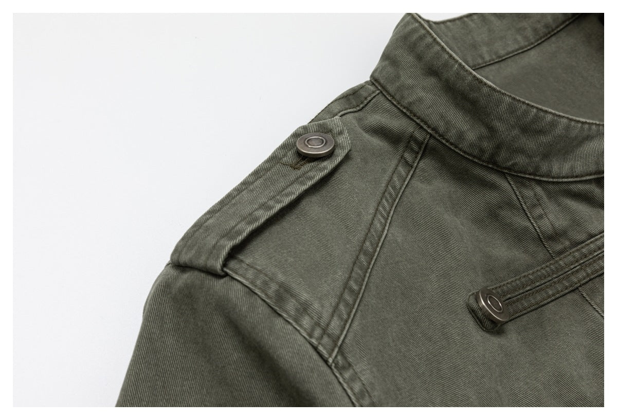 Close-up of an olive-gray jacket shoulder epaulet, stand collar, and metal buttons.