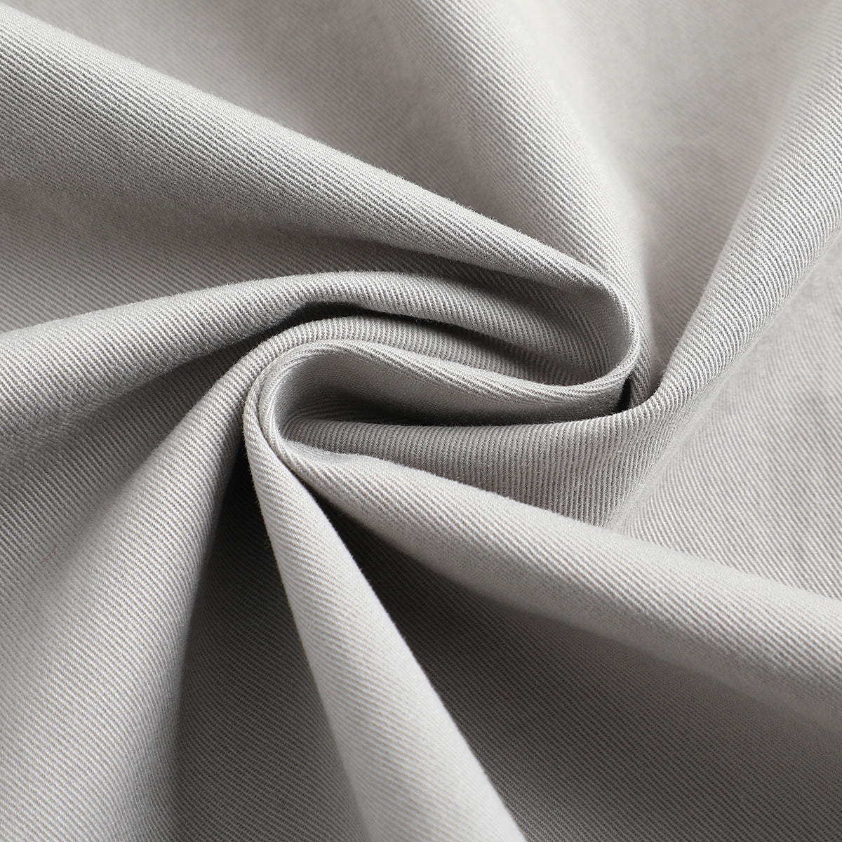 Close-up of light gray fabric gathered to show its diagonal weave and drape.
