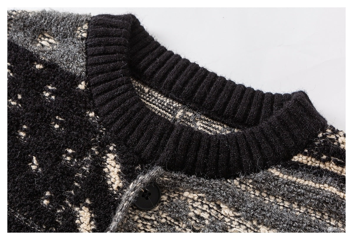 Close-up of a black ribbed crew neckline and button on a black, gray, and cream patterned knit sweater.