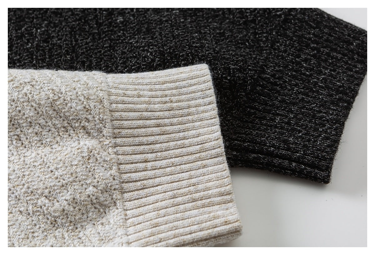 Close-up of cream ribbed knit cuff in front of a black textured sleeve.