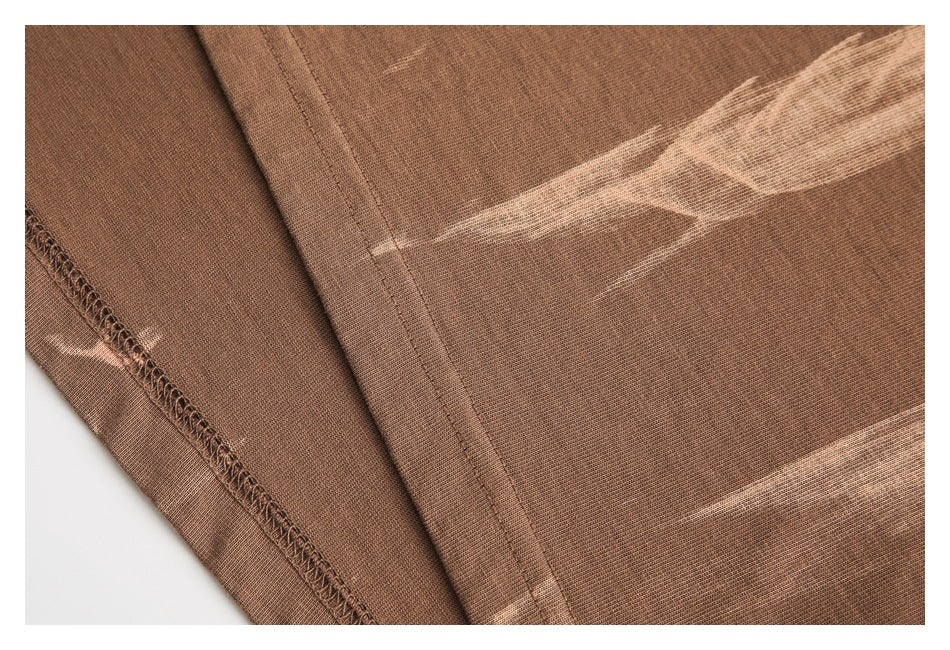 Close-up of brown fabric with pale streaks, a stitched seam, and a visible overlocked edge.