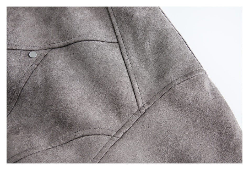 Close-up of gray coat fabric with curved stitched panel seams and a metal snap.