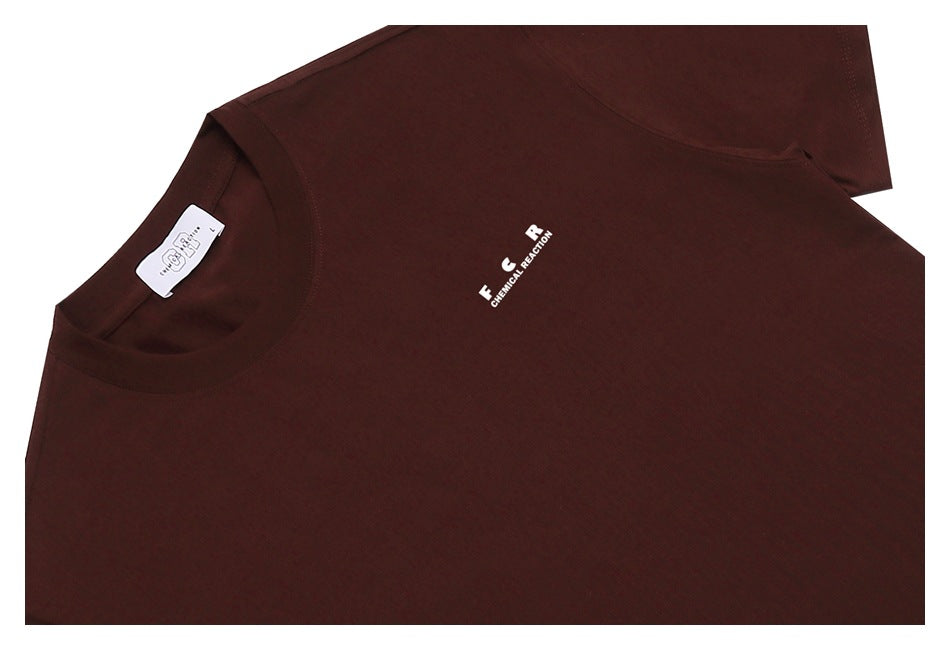 Close-up of a dark brown T-shirt laid flat, showing a small white chest graphic and crew neck.