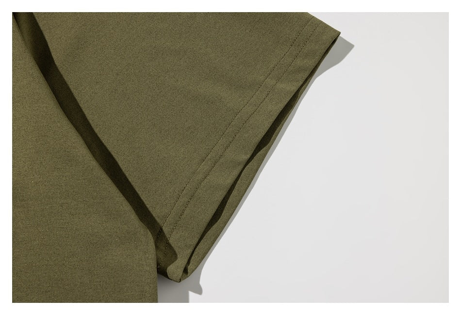 Close-up of the olive-green shirt's short sleeve and double-stitched hem.