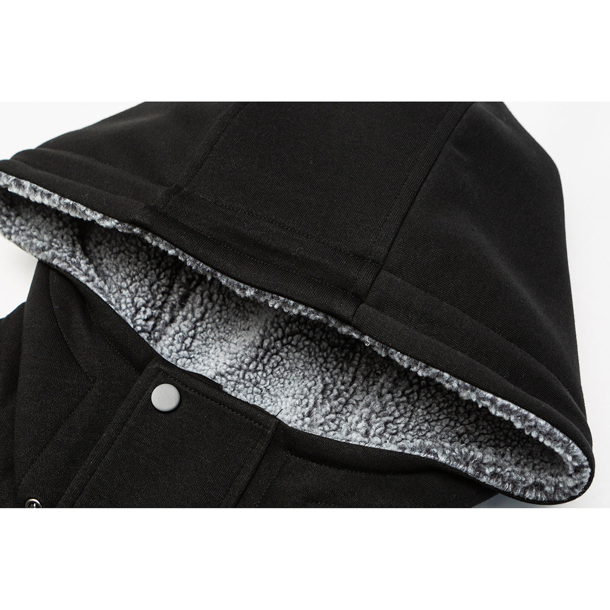 Close-up of a black jacket hood showing gray fleece lining and a silver snap fastener.