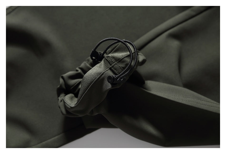 Close-up of a dark olive pant cuff with an adjustable cord and toggle.