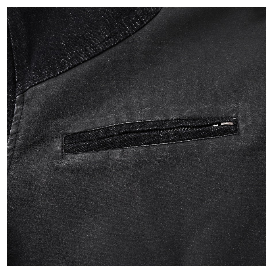 Close-up of a horizontal zip pocket on the black jacket, beside a dark denim panel.
