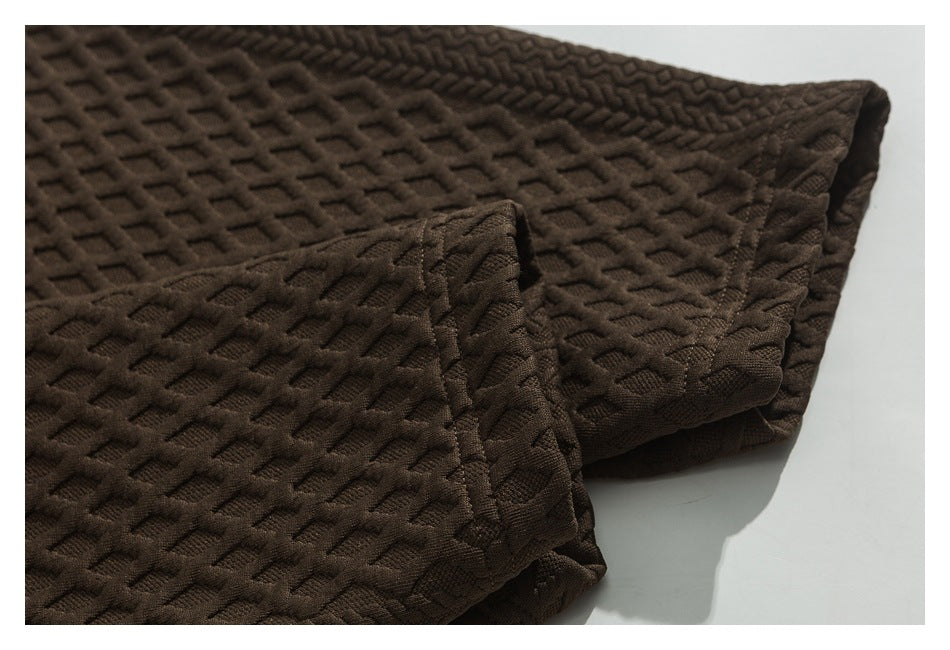 Close-up of the brown jacket's textured sleeve and cuff seam.
