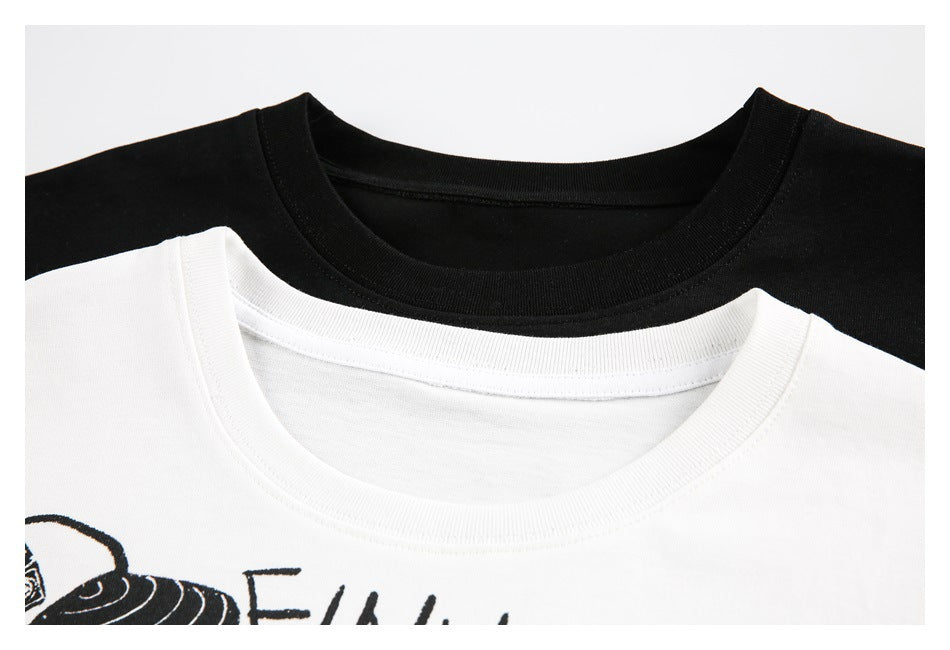 Close-up of black and white T-shirt crew necklines, with part of the white shirt's black graphic visible.