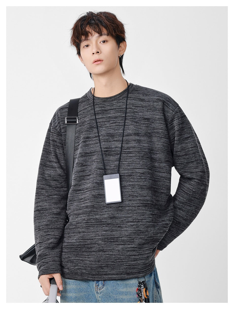 Model wearing an oversized charcoal and gray marled crewneck sweatshirt with long sleeves.