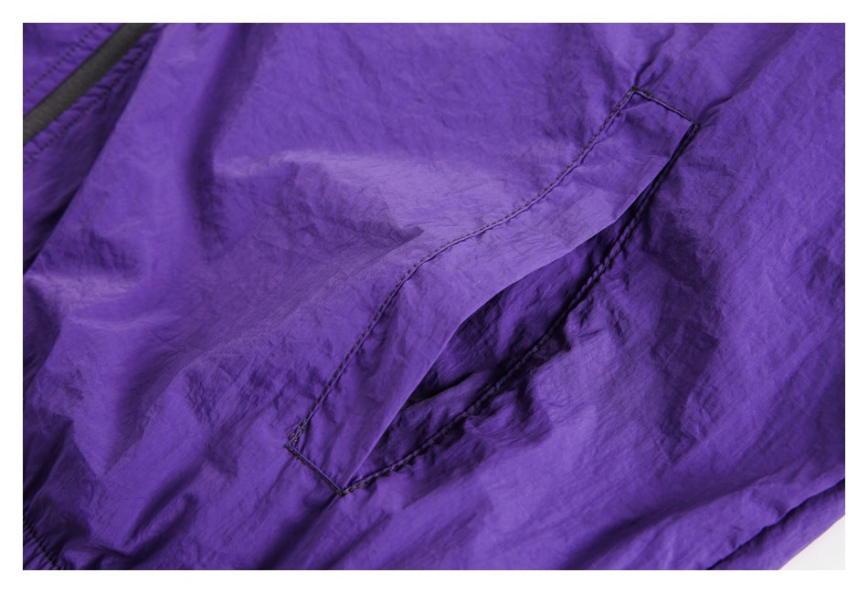 Close-up of a stitched pocket on the purple fabric of a jacket.