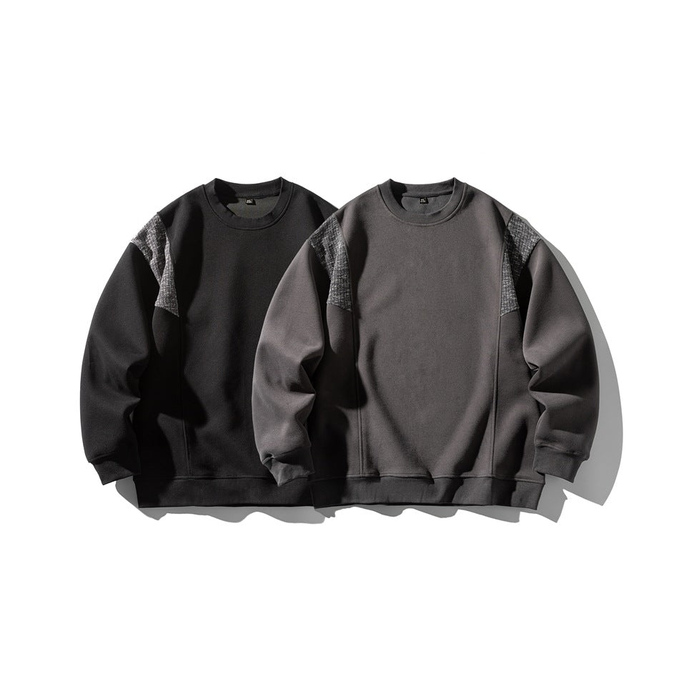Two crewneck sweatshirts displayed side by side in black and charcoal gray, both with textured shoulder panels.